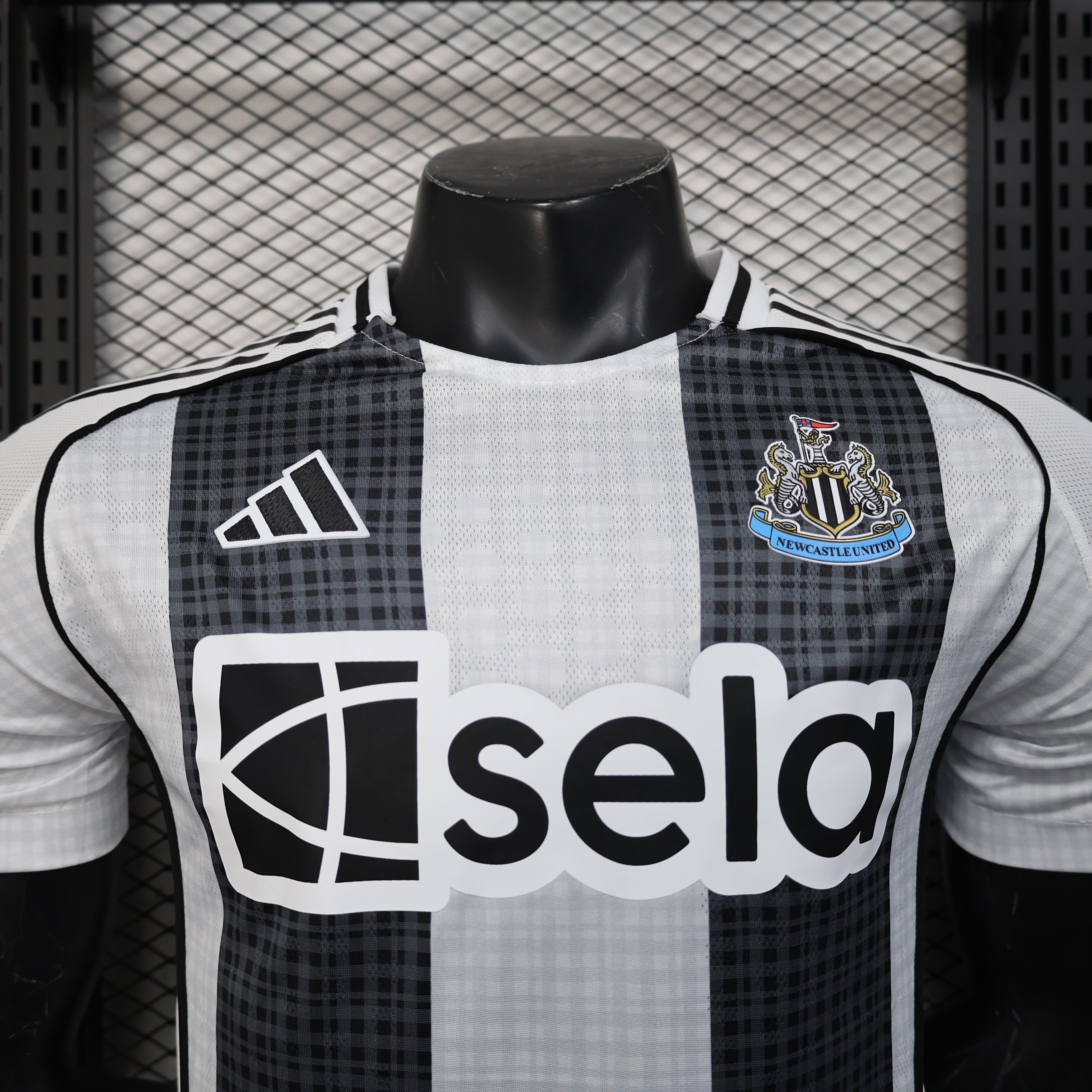 Newcastle United 25/26 home jersey with black-white stripes, checkered shoulders