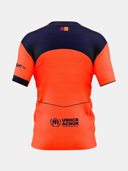 Back of Kids Barcelona 25/26 Third jersey in orange/navy with UNHCR ACNUR logo